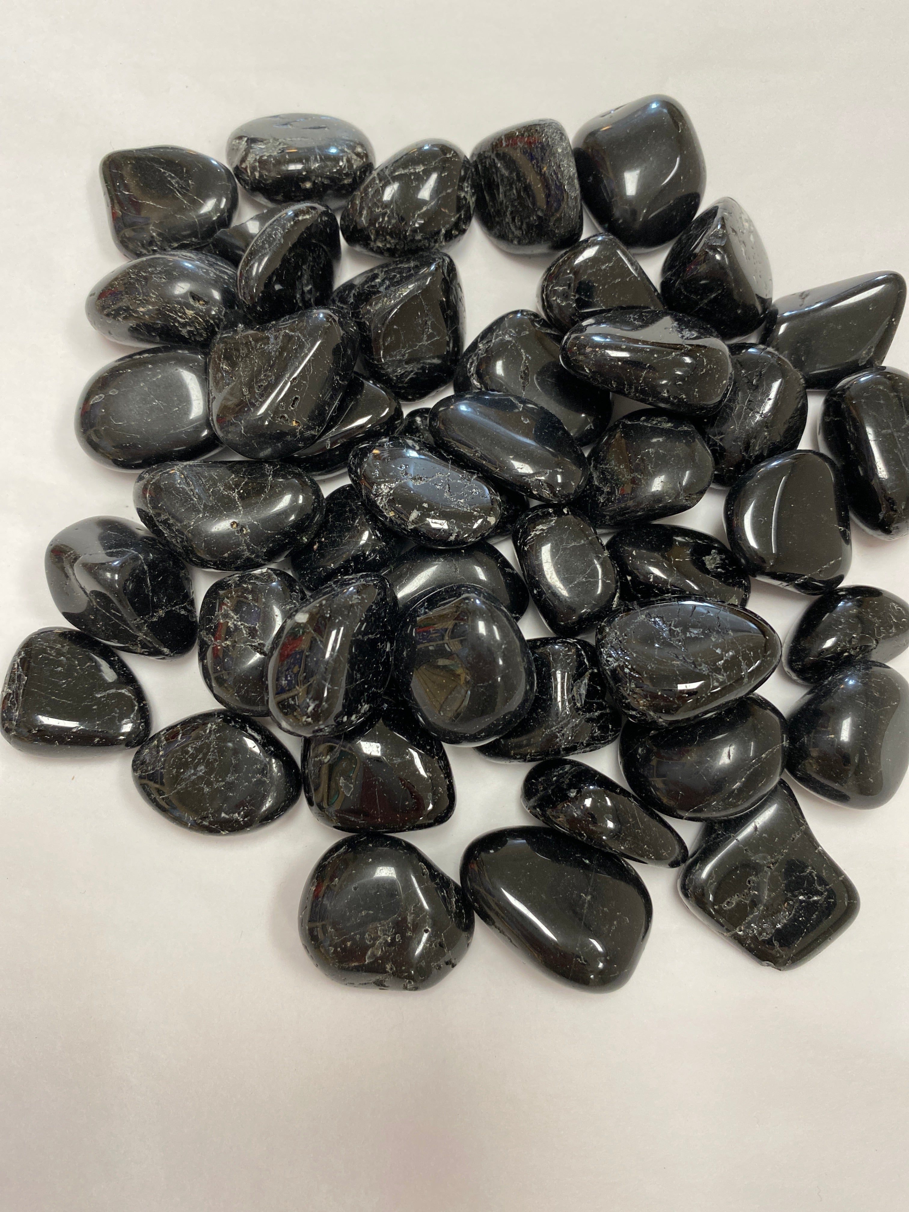 Smooth, black tumbled stone, known for protection, grounding, and negativity shielding.