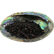 Dried elderberries in an abalone shell.