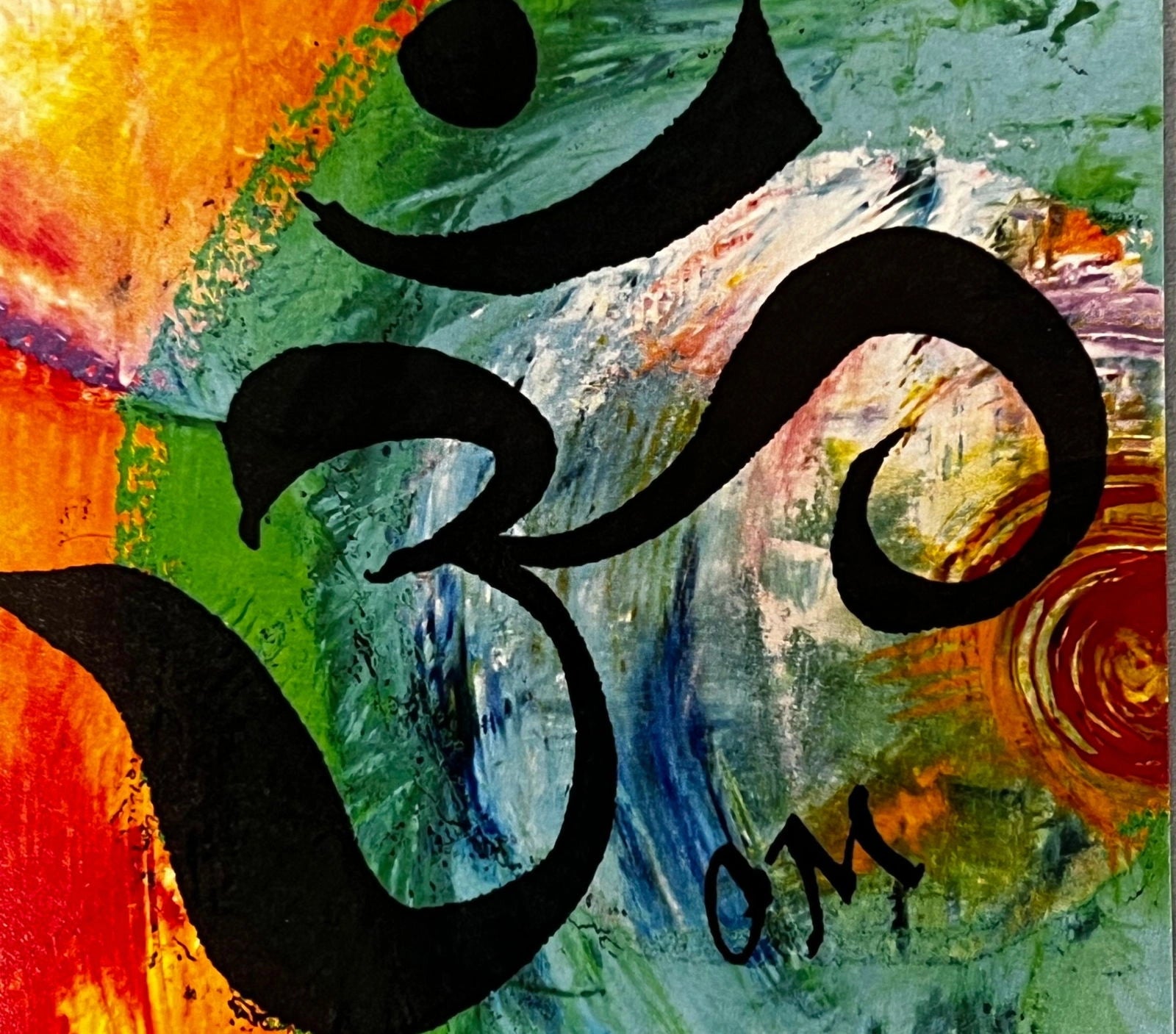 OM magnet with colorful abstract background and black symbol.