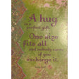 Green greeting card with a quote by Lesin Ball that reads: "A HUG IS A PERFECT GIFT. ONE SIZE FITS ALL AND NOBODY CARES IF YOU EXCHANGE IT."