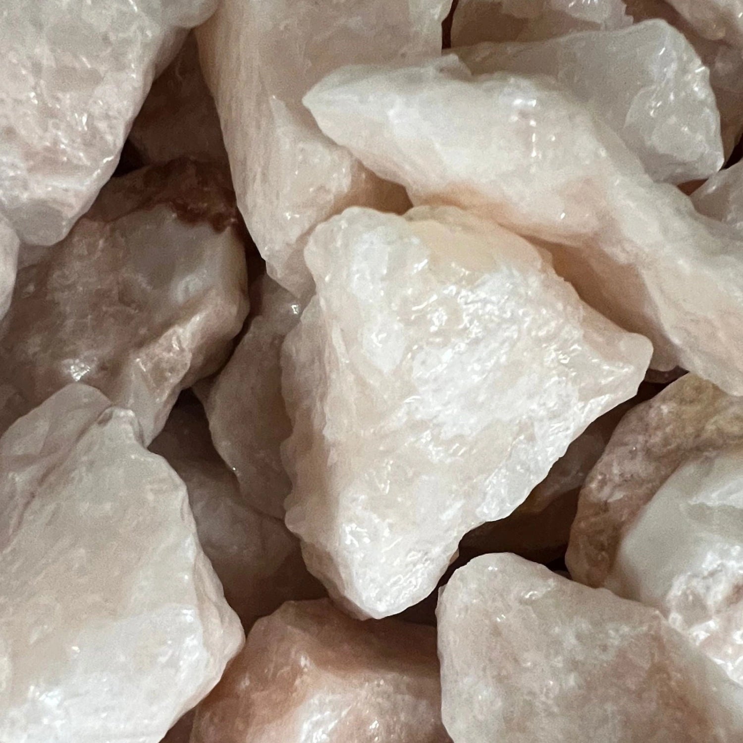 Raw Pink Calcite stones with a rough, natural finish and a pale pink color.