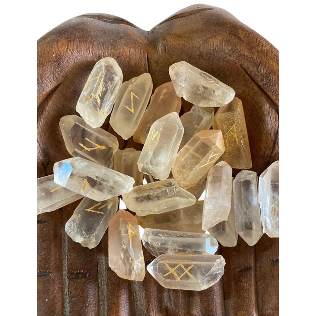 Clear quartz stones with gold runes engraved on them.