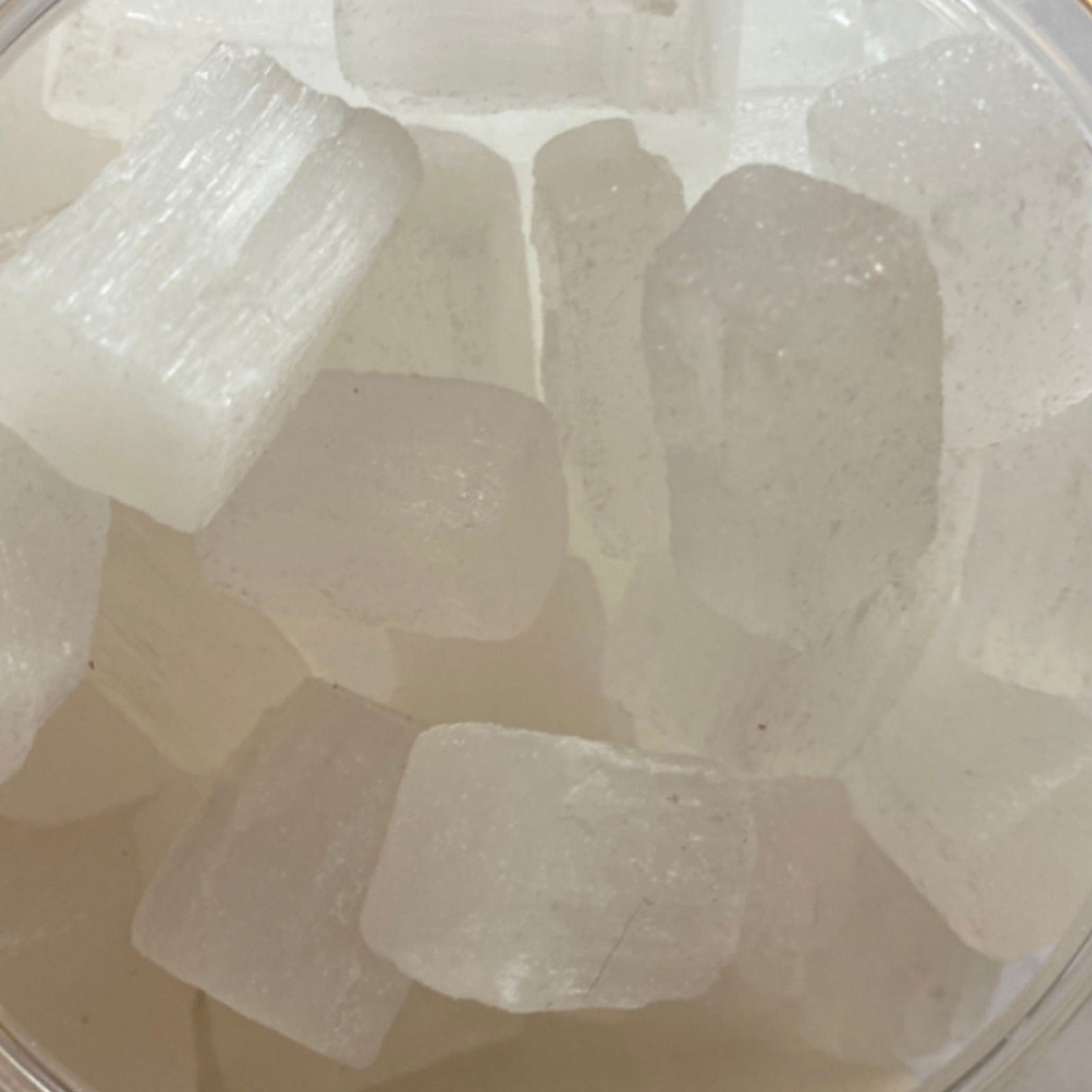 Selenite Tumbled - Close-up of Translucent white stones with smooth surfaces.