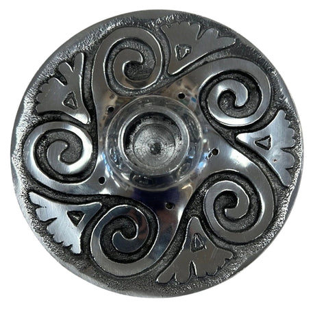 Circular metal candle holder with a raised, intricate spiral design.