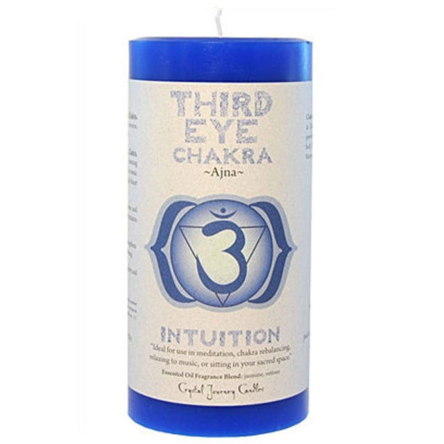 Blue pillar candle with the words "THIRD EYE CHAKRA" and the symbol Ajna printed on it. The candle also features the word "INTUITION" and information about its use for meditation and chakra balancing.