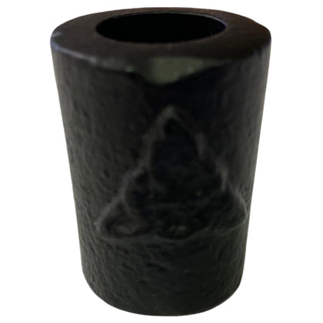 Black cast iron candle holder with a triquetra symbol embossed on it.